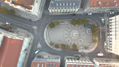 aerial top down view of amazing place to the tourists walking through the historic center with mosaic flooring in lisbon square