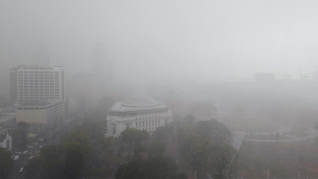 Aerial view of national museum in Rizal Park during torrential rain downpour and poor visibility in capital city of Manila Philippines