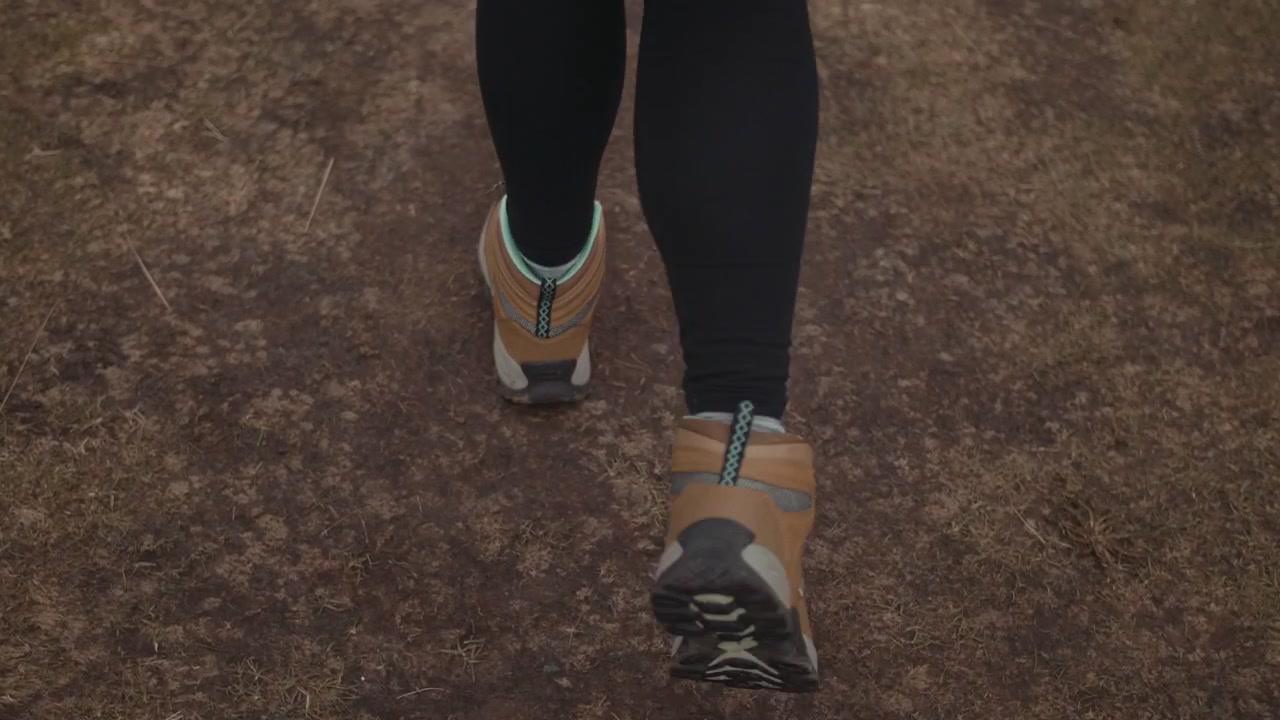 Person's Feet in Hiking Boots Walking on a Dirt Trail