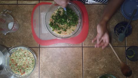 mixing herbs into a traditional recipe for homemade meatloaf - top-down view