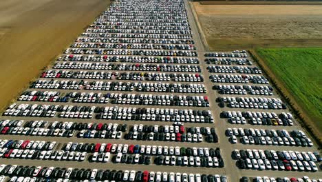 aerial footage of finished cars ready to be shipped on huge distribution center