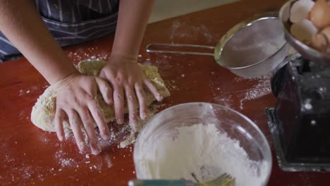 sección media de una mujer caucásica horneando en la cocina