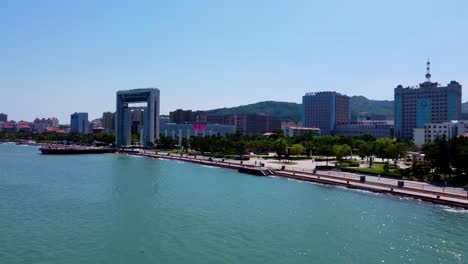 aerial dolly view xingfu park flying from sea side flying toward the city - weihai china