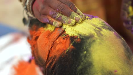 indian man close-up of face smeared with bright holi colors