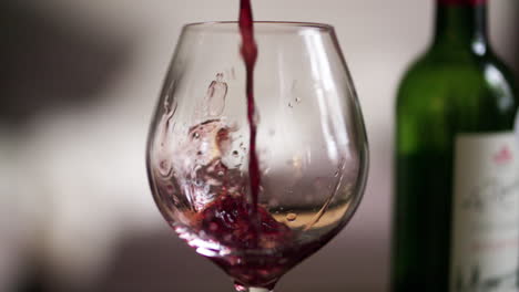 un vaso de vino tinto que se vierte en cámara lenta extrema