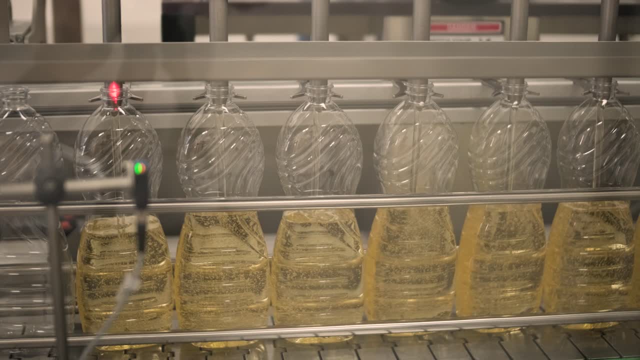 생산 라인에서 움직이는 병에 있는 해바라기 기름. 병에 담긴 해바라지 기름을 병에 담는 라인. 식물성 기름 생산 공장. 첨단 기술. 산업적 배경