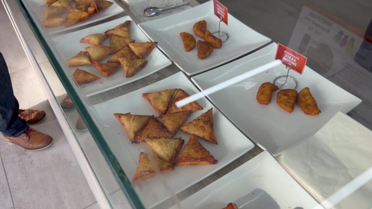 Torte salate e stuzzichini in vetrina in un locale da asporto.