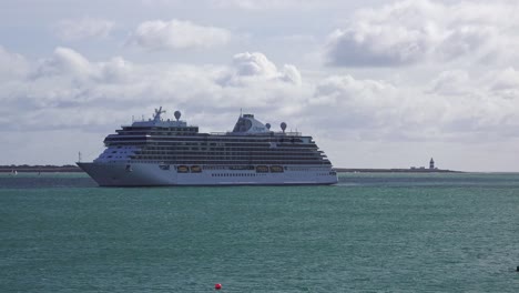 Crucero-Amarrado-Con-El-Faro-De-Hook-Head-En-Segundo-Plano.