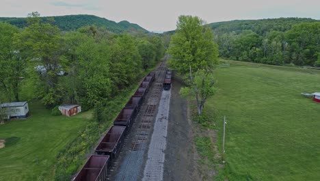 uma vista aérea de uma estrada ferroviária de carvão de bitola estreita abandonada com tremonhas enferrujadas e vagões de carga e edifício de apoio começando a ser restaurado