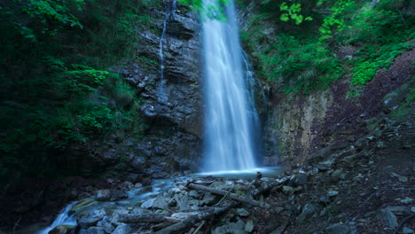 Arcing-time-lapse-of-Fuas-waterfall-down-rocky-cliff-face,-Prato-Carnico