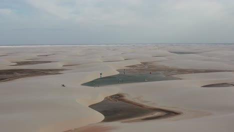 Aerial:-Kitesurfing-in-the-dunes-of-Lencois-Maranhenses,-Northern-Brazil