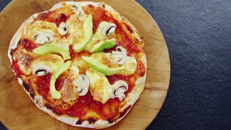 baked pizza with avocado and mushroom toppings