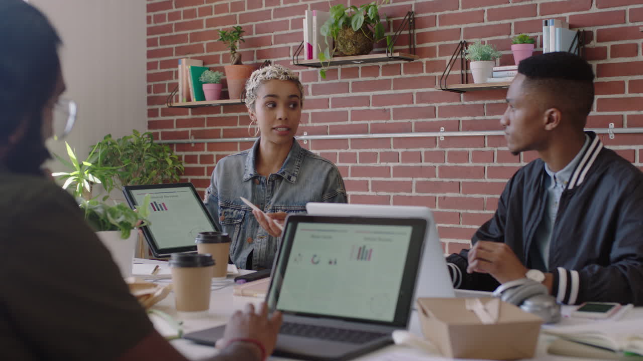 young african american business woman using tablet computer sharing creative ideas presenting project showing colleagues in office meeting diverse team working together brainstorming planning strategy