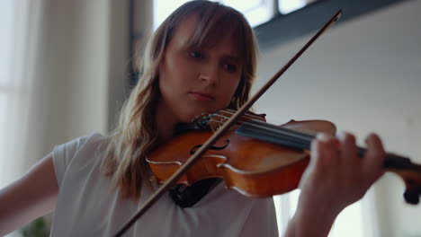 chica practicando música en el violín. violinista creando una canción con un instrumento de cuerdas