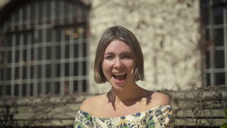 young woman is standing in front an old wall, surprised young woman