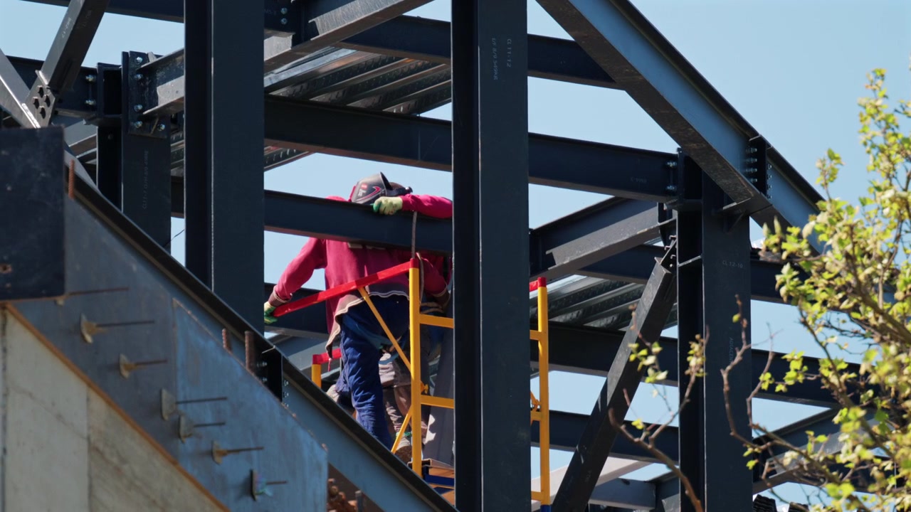 Construction workers assembling a steel frame structure at a building site