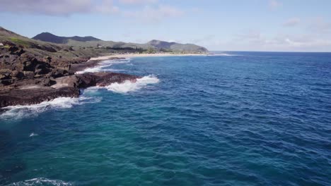 Langsam-Absteigende-Drohnenaufnahmen-Der-Felsigen-Küste-Von-Oahu,-Hawaii,-Zeigen-Das-Wunderschöne-Klare-Blaue-Wasser-Und-Die-Weißen-Wellen,-Die-Auf-Die-Felsige-Vulkanküste-Treffen