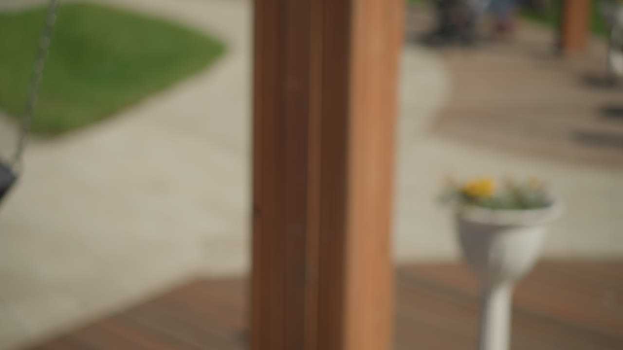 야외에서 흔들리는 여성의 클로즈업, 그녀의 머리카락이 바람과 함께 움직이며, 이 많은 공원 설정에서 배경에 있는 사람들의 흐릿한 시각