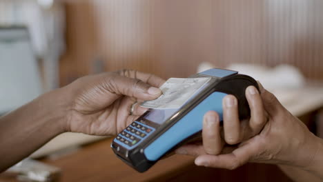 Black-guy-paying-with-credit-card-at-terminal-in-store.