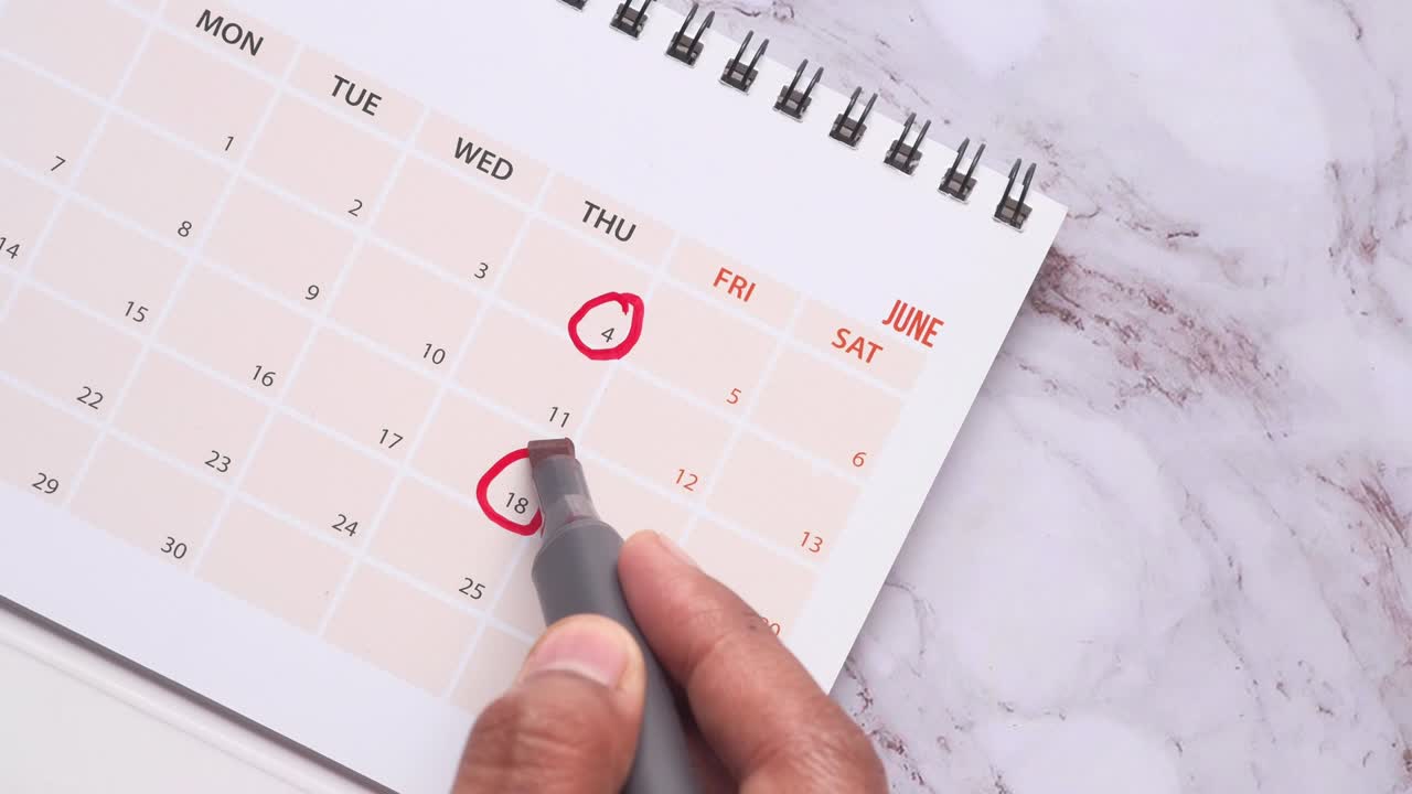 Mannens hånd med penn som markerer på kalender, fristkonsept