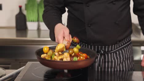 chef cooking chicken with vegetables