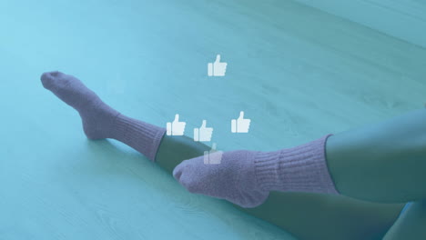 thumbs up icons animation over person wearing purple socks on wooden floor