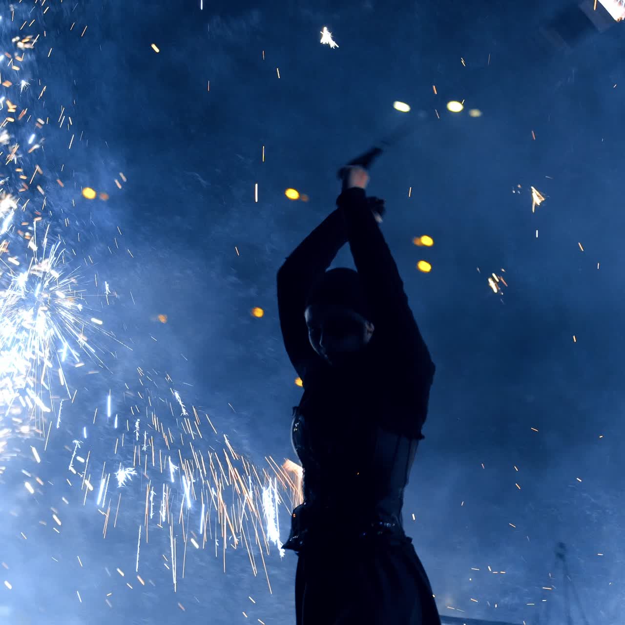 Female performer dancer with fireworks. Woman in black suit rotates the stage props producing sparks of firework