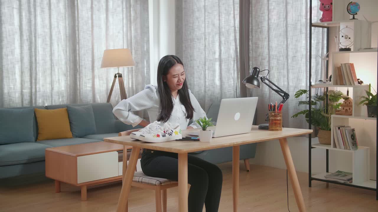 집에서 일하는 동안 허리 통증이 있는 여성