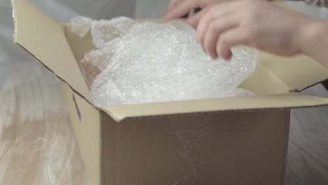 unpacking items in a box with bubble wrap