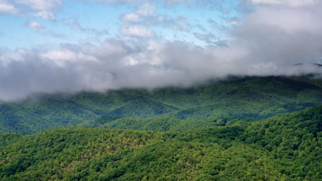 Drone shot of atmospheric clouds cascading into the Smoky Mountain mist