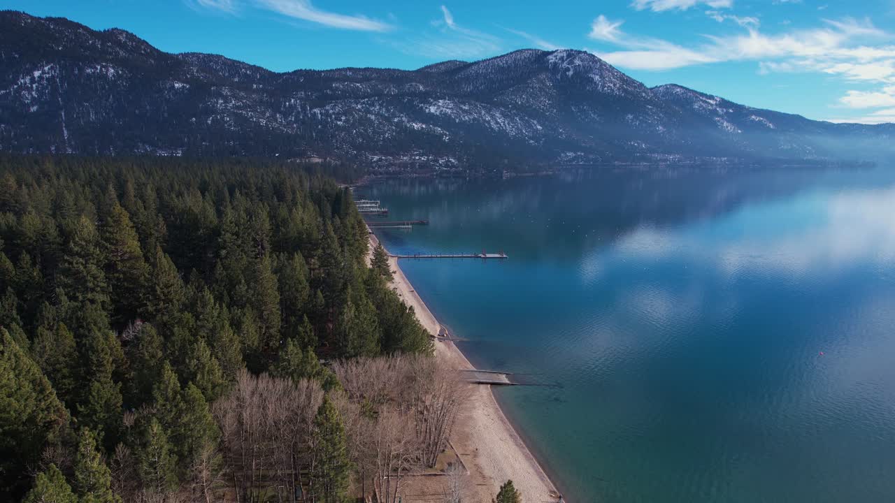 vista aérea del hermoso lago tahoe en un soleado día de invierno, playa y bosque de coníferas, toma de dron