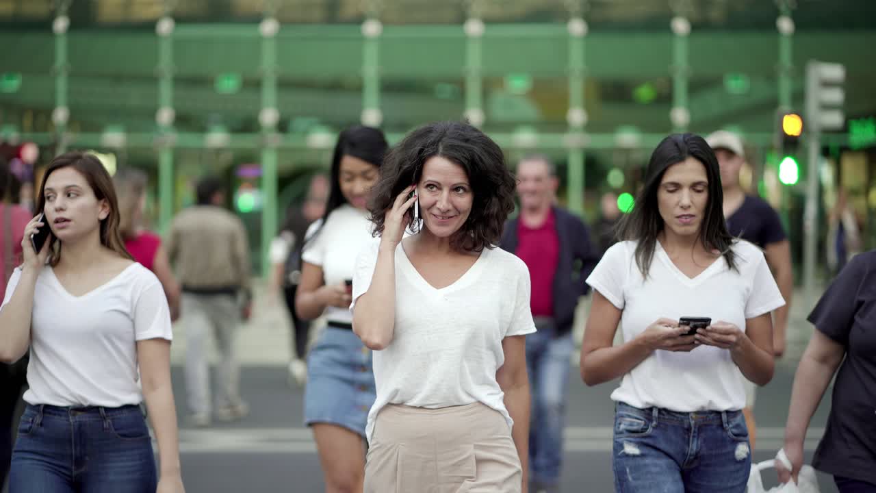 mujer madura sonriente hablando en el teléfono inteligente durante el paseo