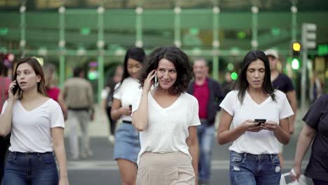 mujer madura sonriente hablando en el teléfono inteligente durante el paseo