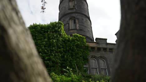 Tilt-up-push-in-through-tree-branches-to-historic-building-nelson-monument-Scotland