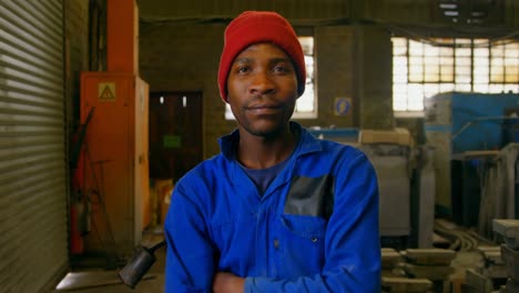 male worker standing with arms crossed in workshop 4k