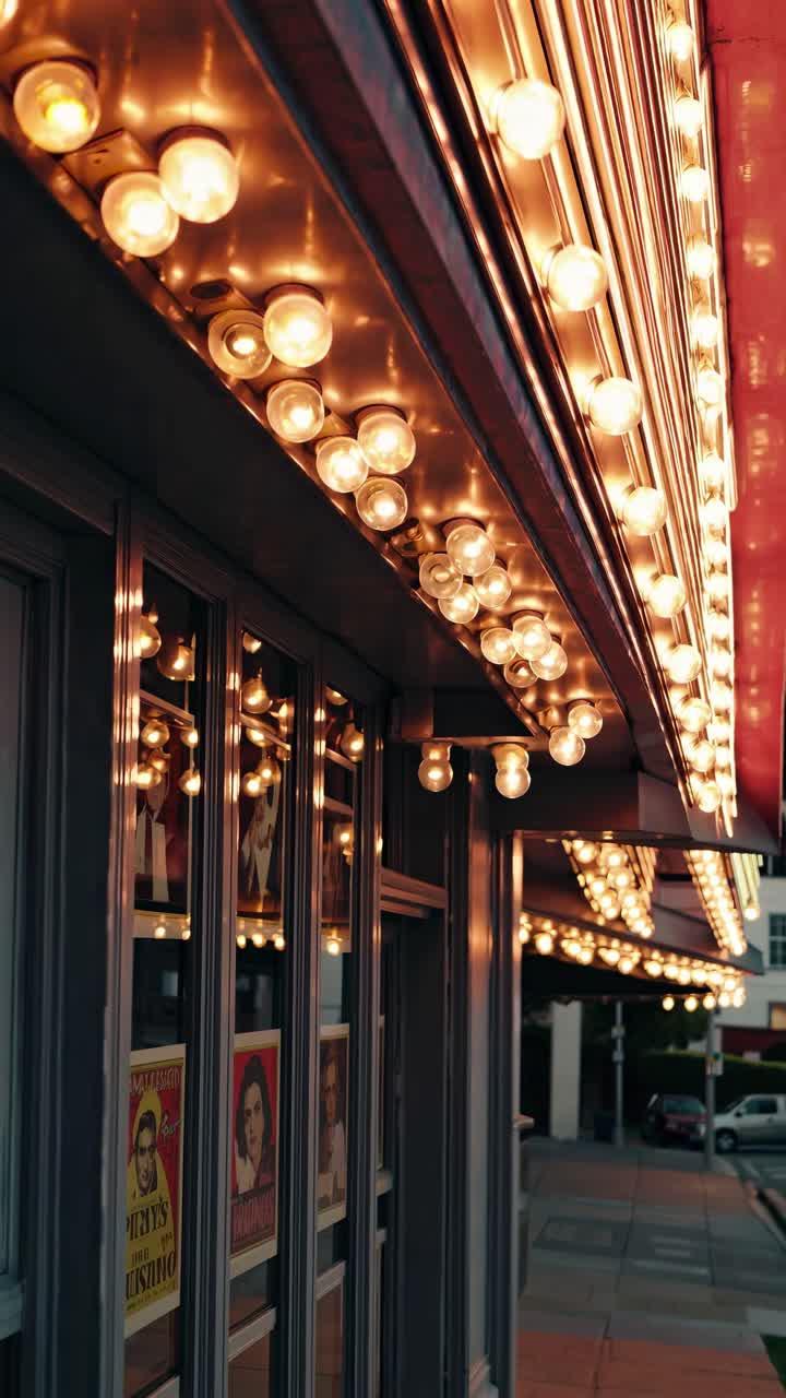 Warm-lit marquee with vintage posters, captured from a low angle, evokes classic cinema vibes