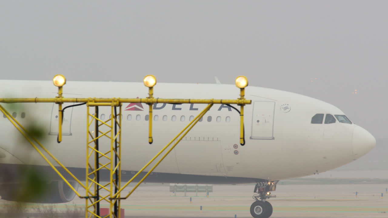 avión delta en la vía de rodaje en la niebla