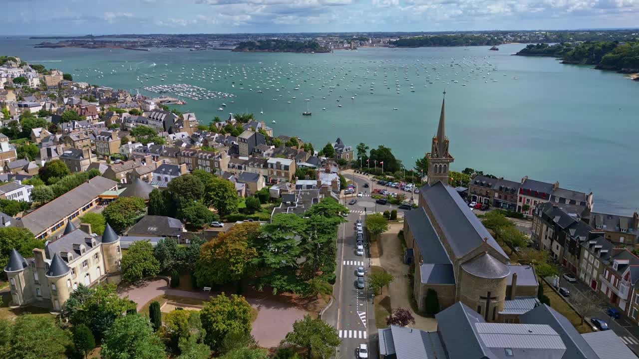 Notre Dame d’Emeraude seen from above with Saint Malo and coast visible in the background, tracking right panoramic aerial