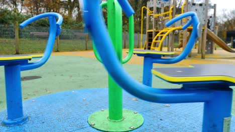 slow pull back shot of merry go round spinning in empty play area