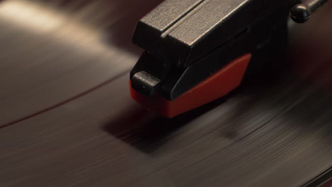 macro of a vintage style retro record player needle and spinning vinyl music album