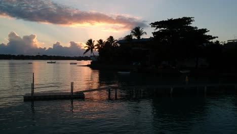 Eine-Seitliche-Luftaufnahme,-Die-Bei-Sonnenaufgang-Tief-Von-Einem-Kleinen-Pier-Fliegt