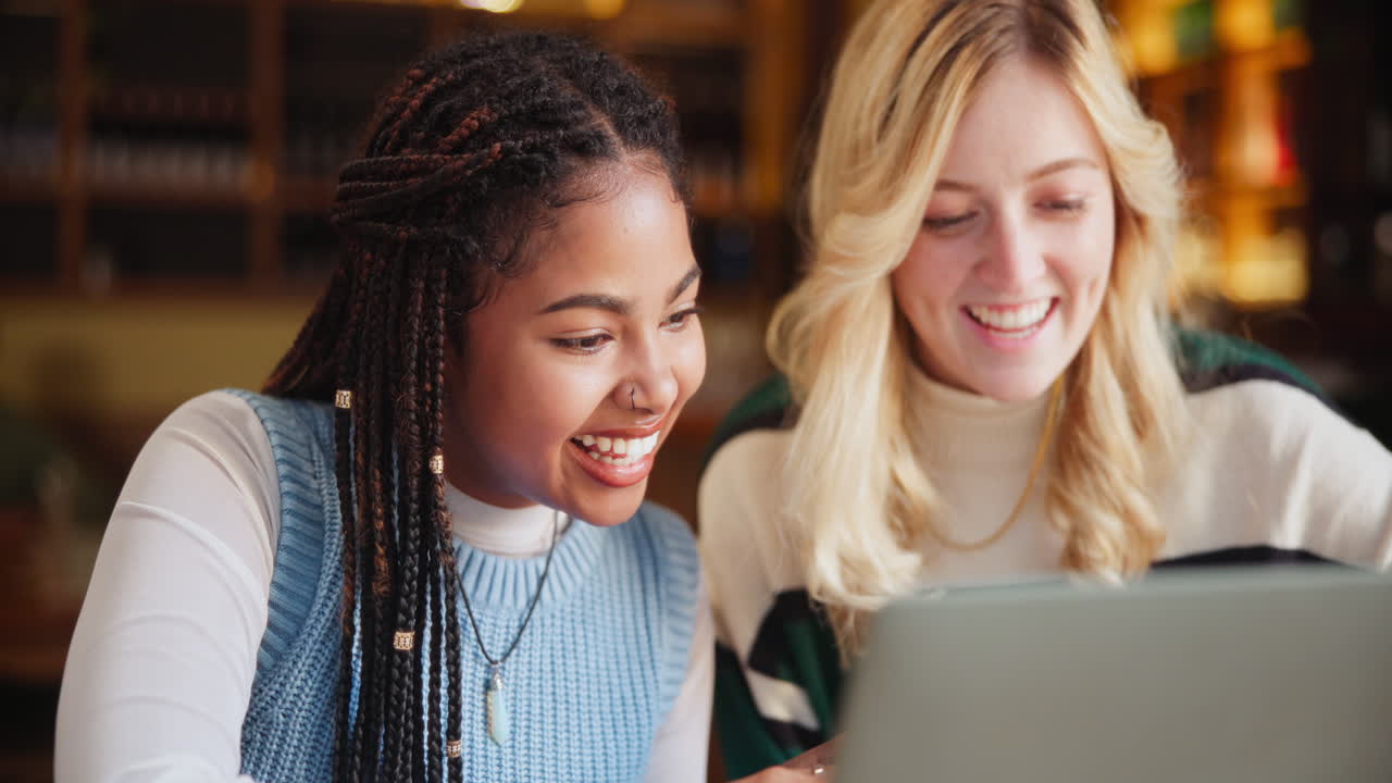 Two friends laughing together at a cafe