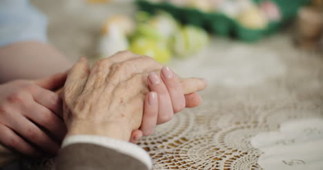 woman comforting wrinkled old hand 2