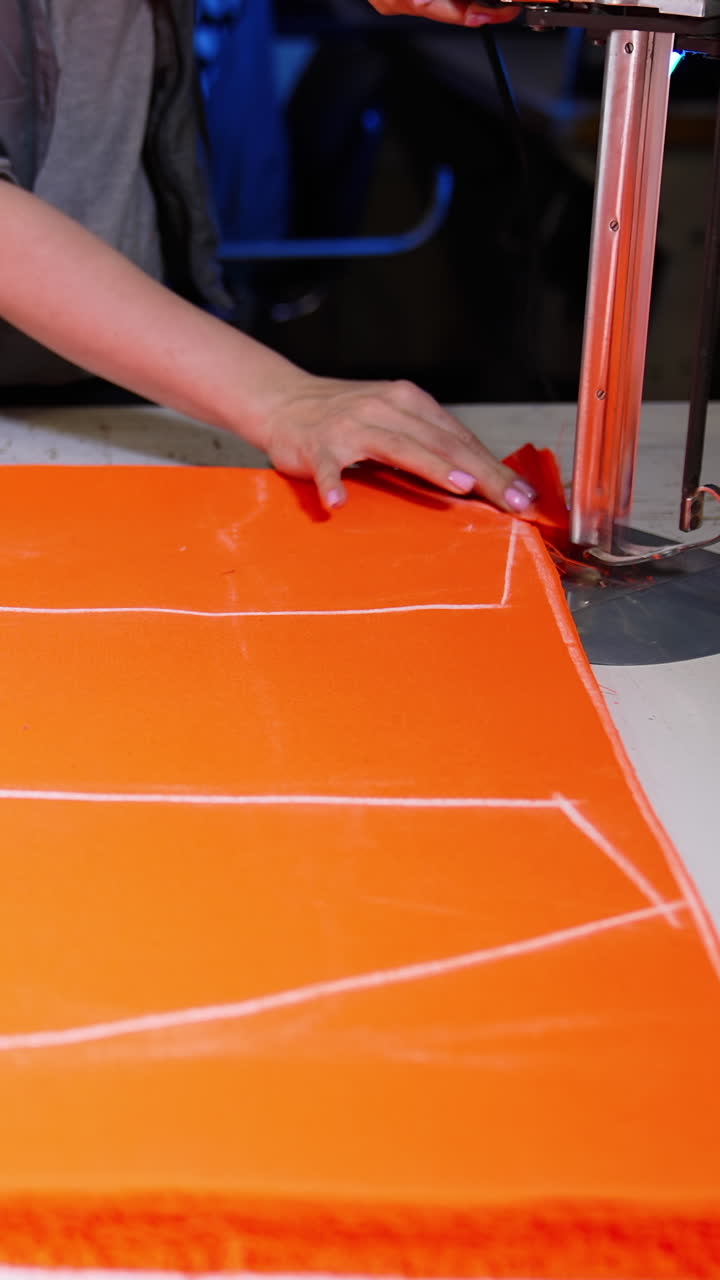 Máquina de costura industrial para tecidos. Close-up de máquina de costura trabalhando em fábrica têxtil. Vídeo vertical