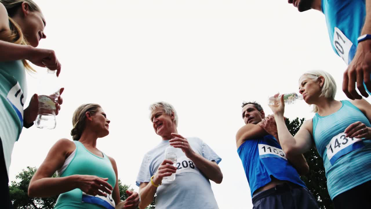 Famiglia atletica che discute e beve acqua.