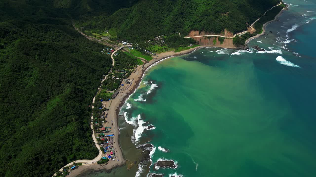 Rotating aerial shot of the Matawe Rock Formations in Dingalan, Aurora, circling rugged coastal rocks as waves crash against them, revealing the dramatic beauty of the shoreline