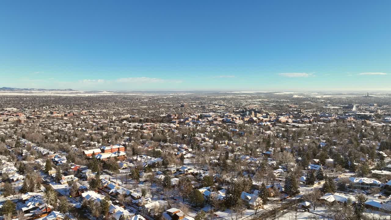 Video aereo con drone della città di Boulder, Colorado, dopo una tempesta di neve in una mattina limpida con l'Università del Colorado Boulder sullo sfondo.