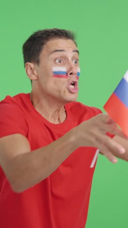 Man cheering for Russia waving a national flag looking away