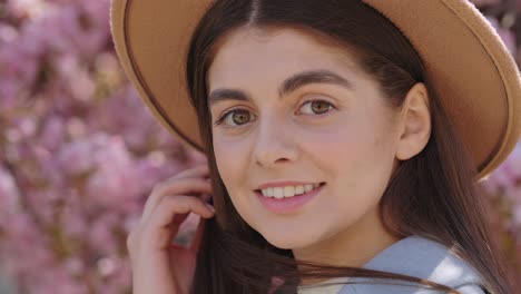 woman wearing a hat in a blooming spring garden
