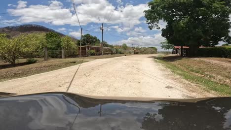 Graues-Fahrzeug,-Das-Auf-Unbefestigter-Straße-Im-Ländlichen-Costa-Rica-Vorrückt,-Hält-Dann-In-Der-Nähe-Des-Bauernhofes-An,-Vordere-Autohaube-Erschossen